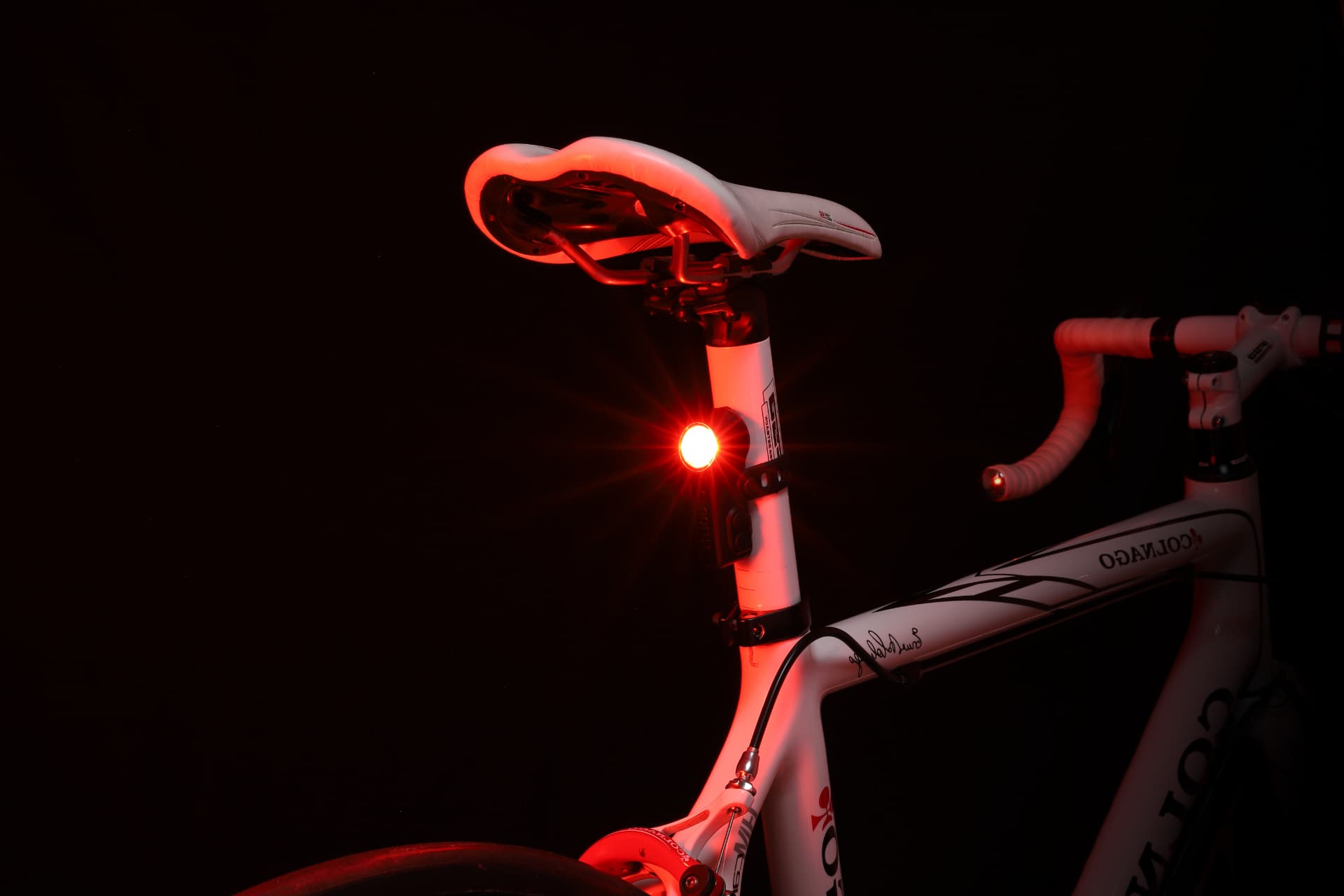 Cygolite Slingshot taillight lit on a road bike seatpost at night