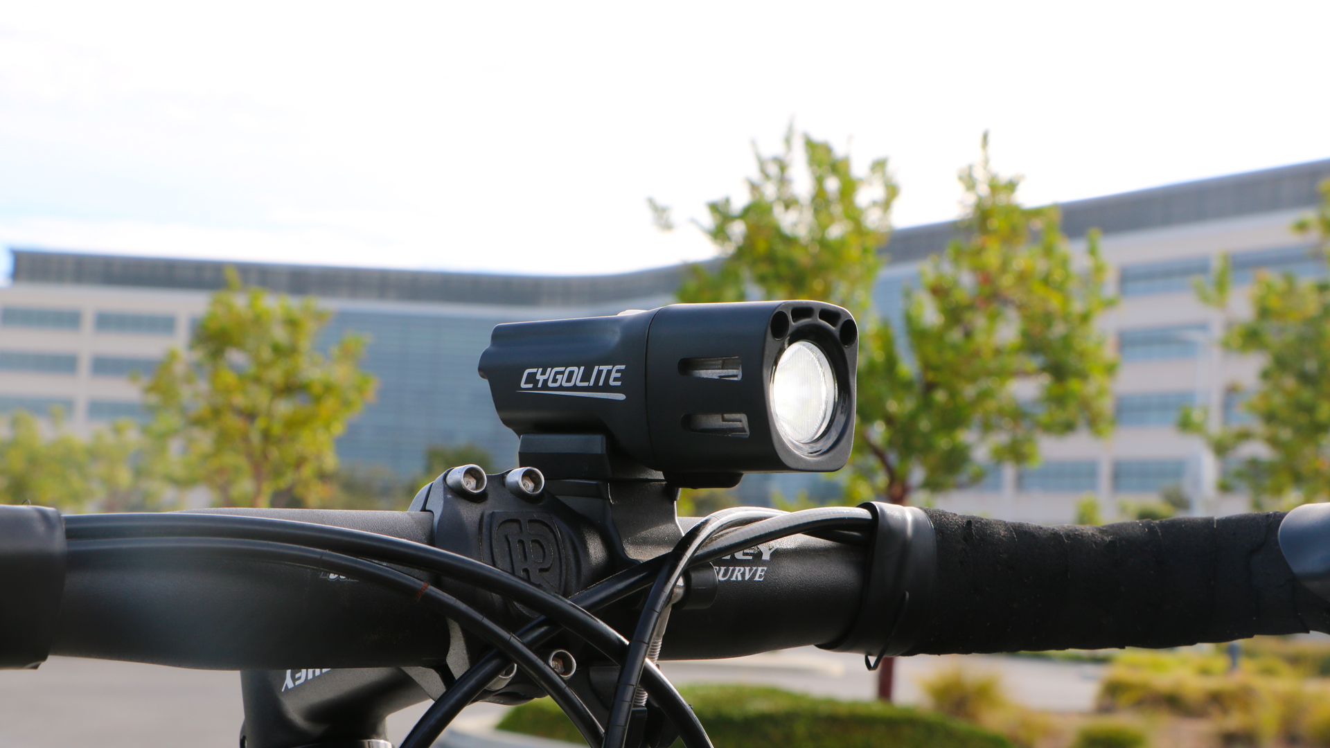 Cygolite City Micro headlight lit on drop handlebars on a bright day